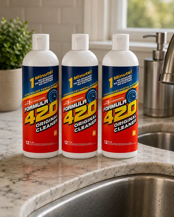 Three 12 fluid ounce bottles of Formula 420 pipe cleaner standing in a row on a granite counter beside a kitchen sink