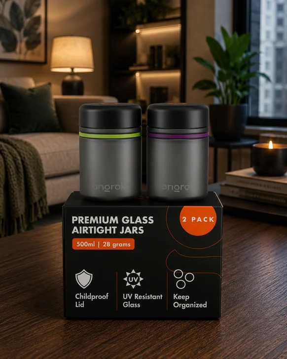 Two gray ONGROK glass storage jars with black child-resistant lids and colored seal rings, standing on their retail box on a dark wooden table